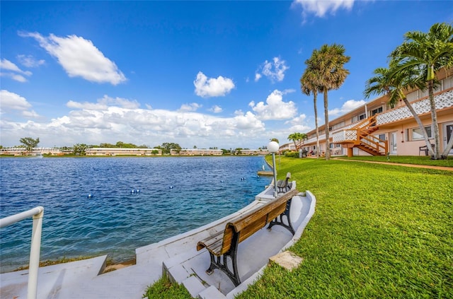 dock area with a water view and a yard