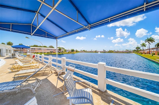 view of dock with a water view and a patio