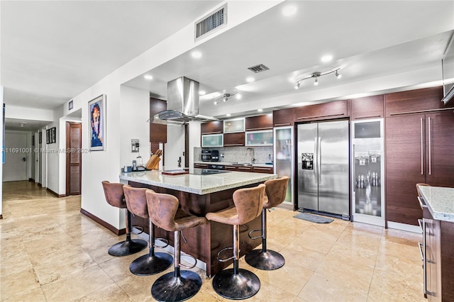 kitchen featuring stainless steel appliances, sink, light stone counters, and exhaust hood