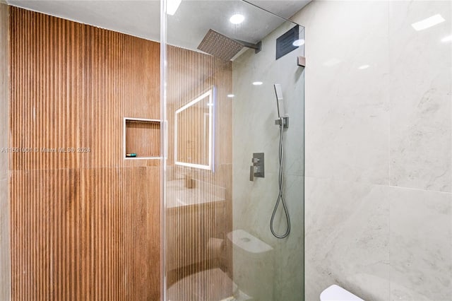 bathroom featuring toilet and a tile shower