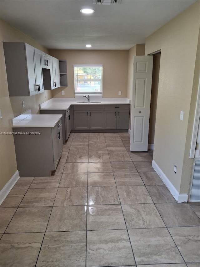 kitchen featuring gray cabinets and sink