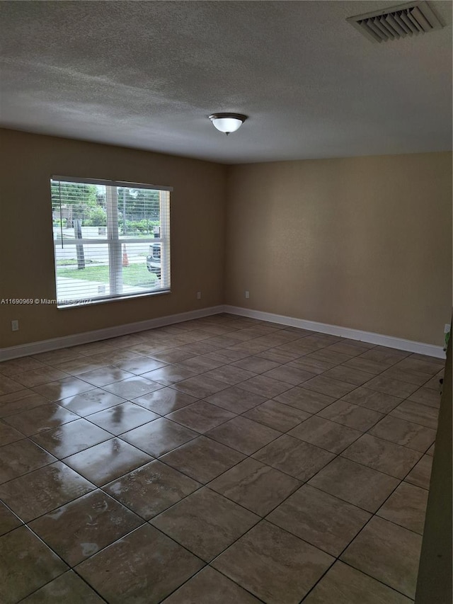 unfurnished room featuring a textured ceiling