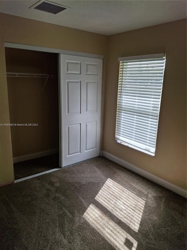 unfurnished bedroom with carpet flooring and a closet