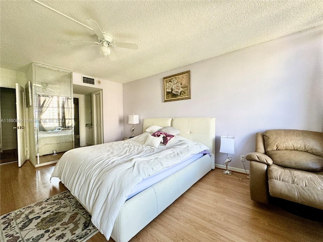 bedroom with light hardwood / wood-style floors, a textured ceiling, and ceiling fan