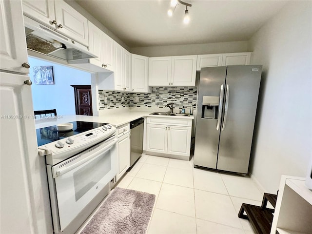 kitchen with stainless steel appliances, sink, light tile patterned floors, backsplash, and white cabinetry