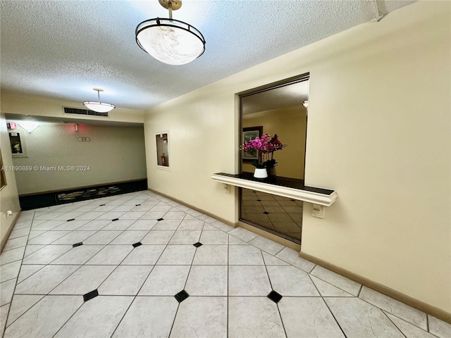 hallway with tile patterned flooring and a textured ceiling