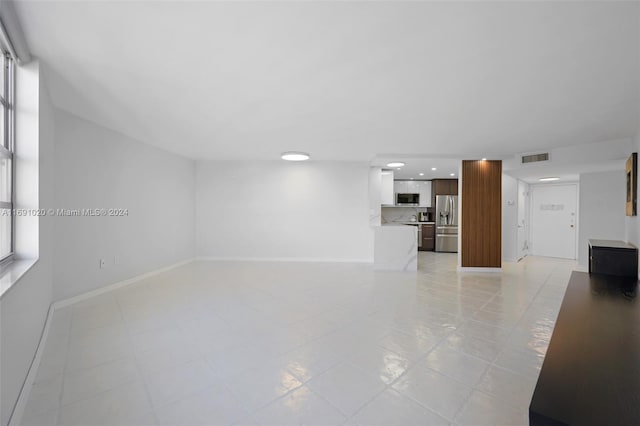 unfurnished living room featuring light tile patterned flooring