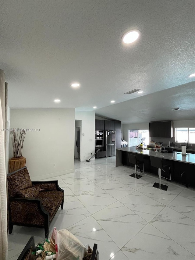 living room featuring a textured ceiling and a healthy amount of sunlight