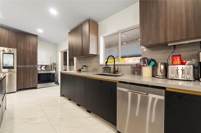 kitchen with stainless steel appliances, dark brown cabinets, sink, and decorative backsplash