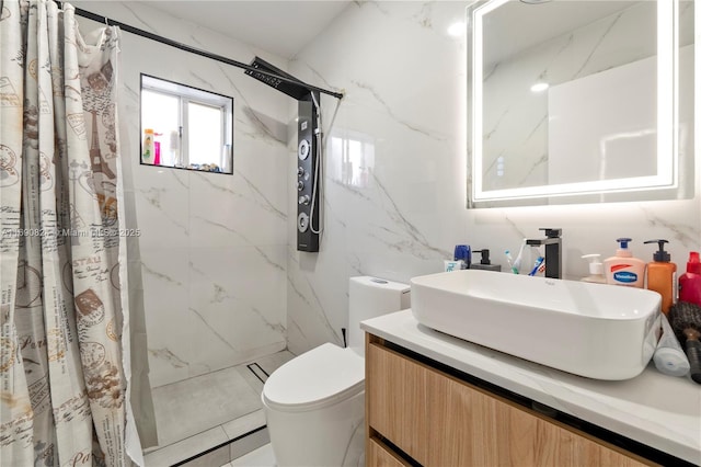 bathroom with vanity, curtained shower, tile walls, and toilet