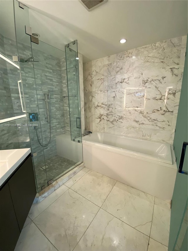 bathroom with vanity and shower with separate bathtub