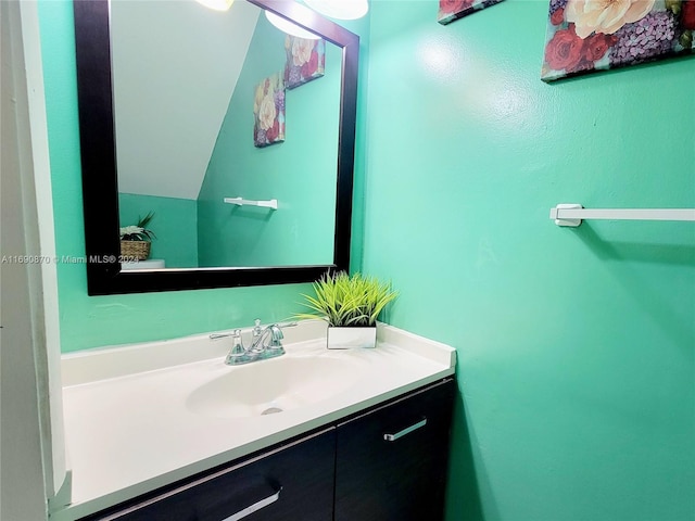 bathroom with vanity and lofted ceiling