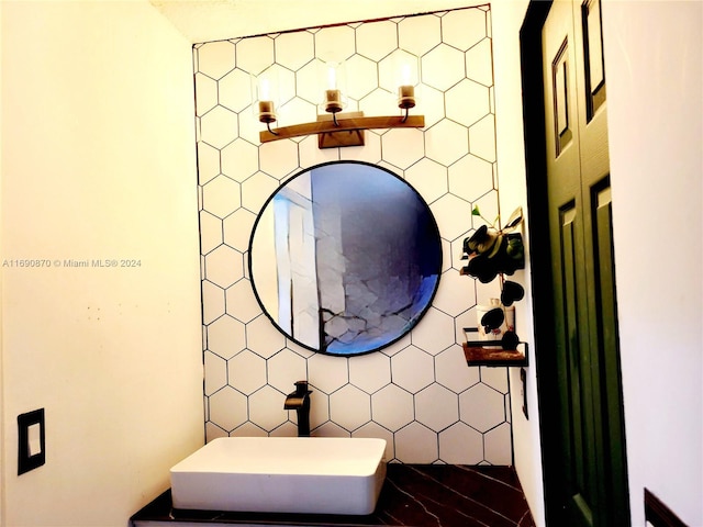 bathroom featuring tasteful backsplash, sink, and tile walls