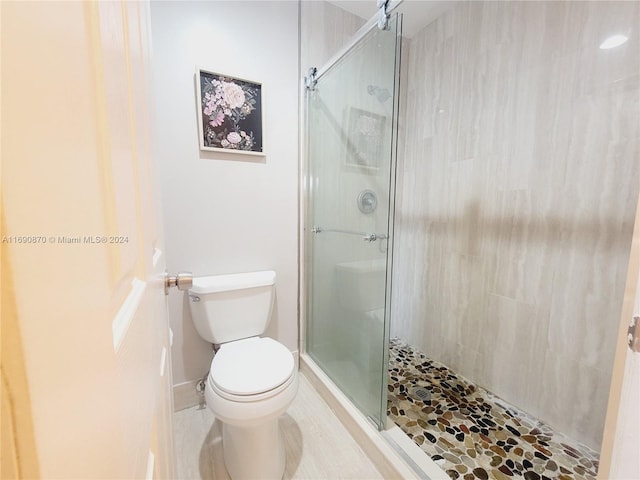 bathroom with toilet and an enclosed shower