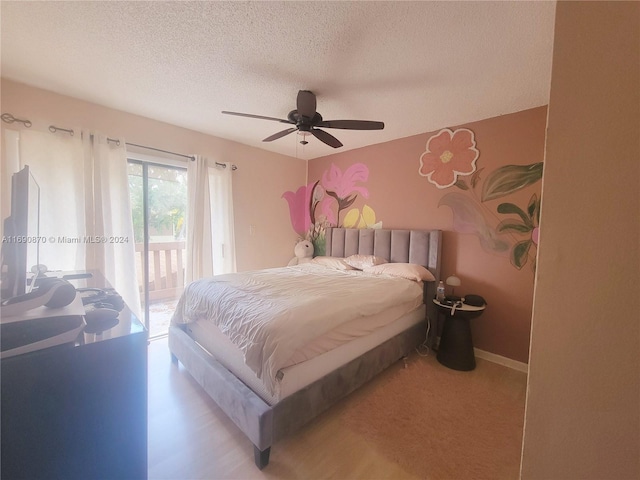 bedroom with access to exterior, ceiling fan, and a textured ceiling