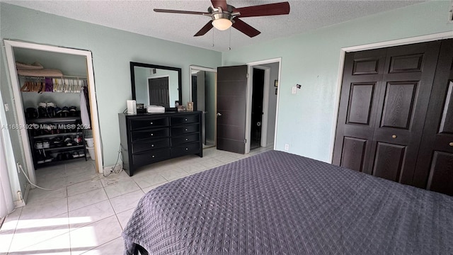 bedroom featuring a textured ceiling, ensuite bath, and ceiling fan