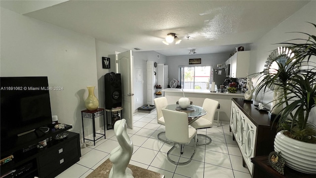 dining area featuring a textured ceiling and light tile patterned floors