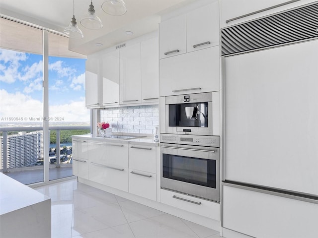 kitchen with light tile patterned flooring, white cabinetry, paneled built in refrigerator, backsplash, and pendant lighting