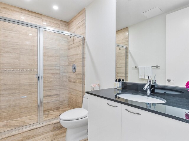 bathroom with toilet, vanity, and walk in shower