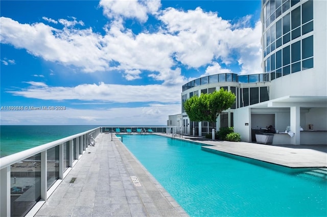 view of swimming pool featuring a water view