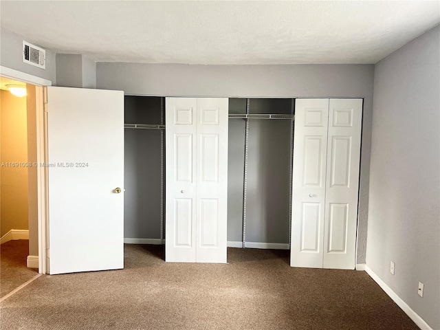 unfurnished bedroom featuring two closets and carpet floors