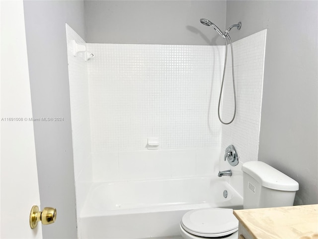 full bathroom with tiled shower / bath, toilet, and vanity