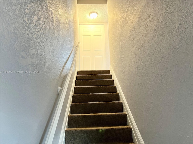 stairway with a textured ceiling