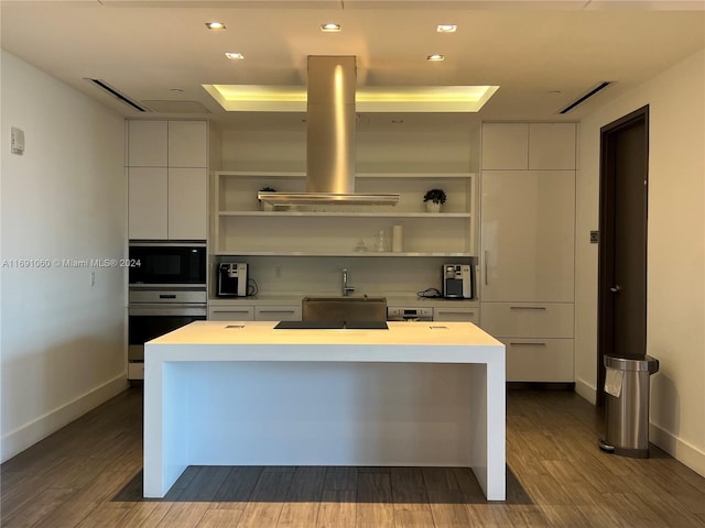 kitchen with a center island, black appliances, white cabinets, ventilation hood, and hardwood / wood-style flooring