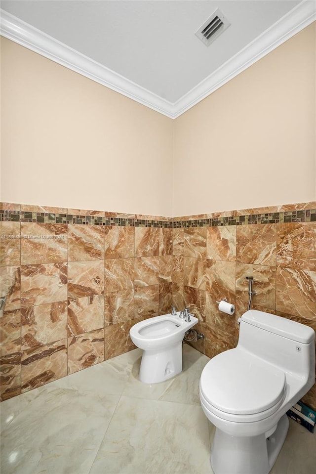 bathroom with tile walls, toilet, a bidet, and crown molding