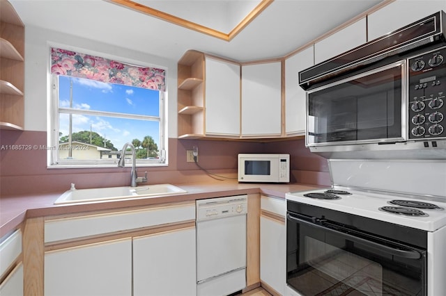 kitchen featuring white cabinetry, sink, and white appliances