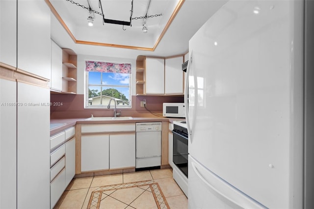 kitchen featuring light tile patterned floors, white appliances, white cabinetry, and sink