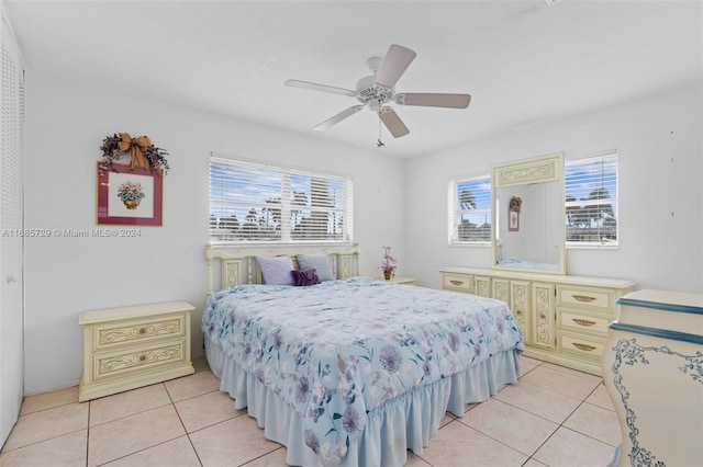 bedroom featuring ceiling fan, light tile patterned flooring, and multiple windows