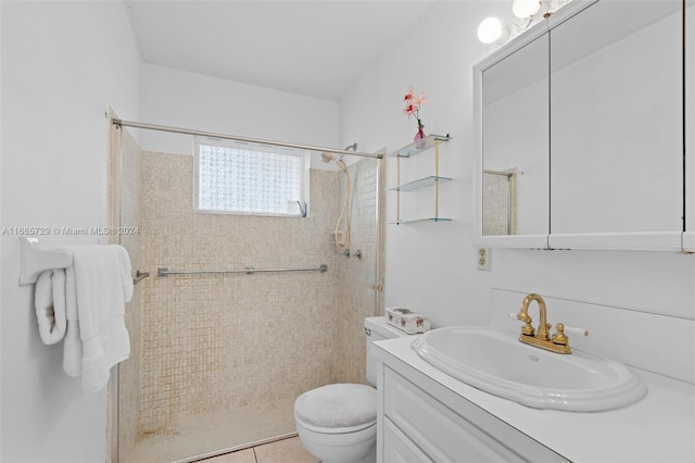 bathroom with tile patterned floors, vanity, toilet, and tiled shower