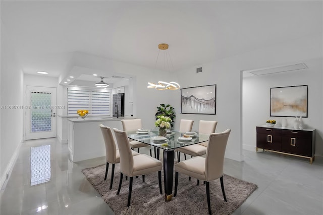 tiled dining room with an inviting chandelier