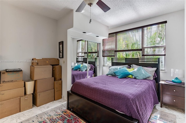 bedroom with multiple windows, ceiling fan, and a textured ceiling