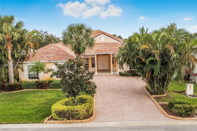 174 NW Magnolia Lakes Blvd, Port St Lucie, FL 34986 - view of front of home featuring decorative driveway, a tile roof, stucco siding, and a front lawn