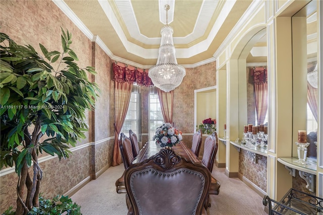 carpeted dining room featuring a raised ceiling, crown molding, and a chandelier