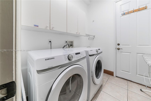 174 NW Magnolia Lakes Blvd, Port St Lucie, FL 34986 - washroom with cabinet space, washer and clothes dryer, and light tile patterned flooring