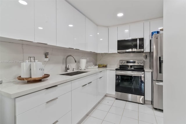 kitchen with white cabinets, sink, backsplash, and appliances with stainless steel finishes