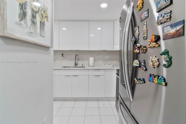 kitchen featuring white cabinetry, light tile patterned flooring, sink, and stainless steel fridge