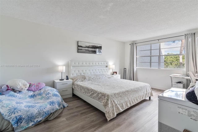 bedroom with dark hardwood / wood-style flooring and a textured ceiling