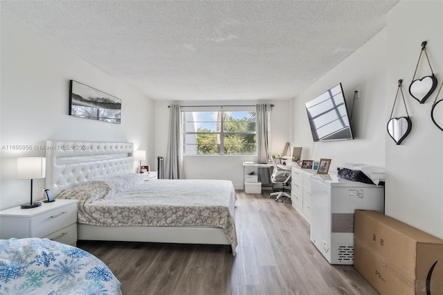 bedroom featuring hardwood / wood-style floors and a textured ceiling