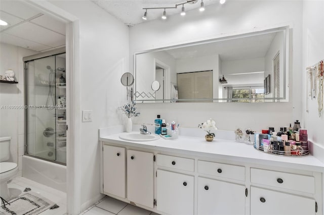 full bathroom with tile patterned flooring, enclosed tub / shower combo, toilet, and vanity