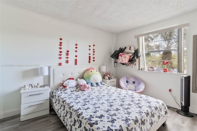 bedroom with a textured ceiling and dark hardwood / wood-style floors