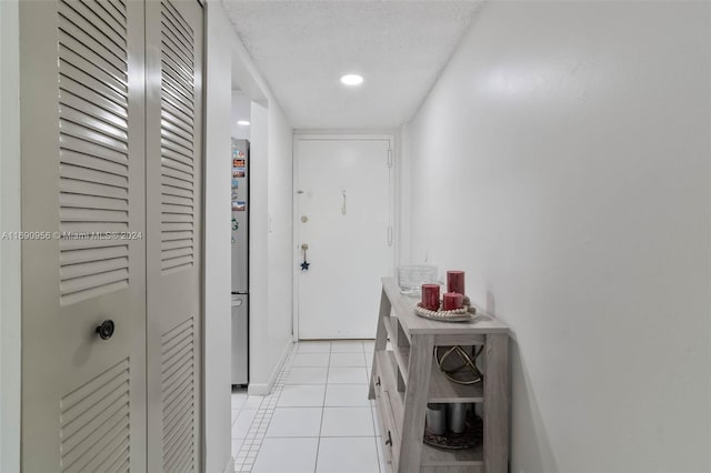 hallway featuring a textured ceiling and light tile patterned floors