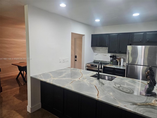 kitchen featuring light stone counters, sink, stainless steel appliances, and tasteful backsplash