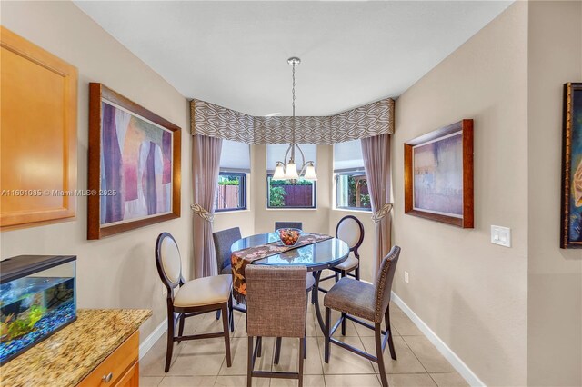 dining space featuring light tile patterned floors and a notable chandelier