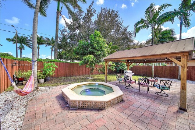 view of swimming pool with an outdoor hot tub, a gazebo, and a patio area