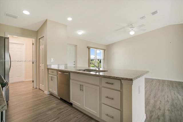 kitchen featuring white cabinetry, light stone countertops, sink, stainless steel appliances, and wood-type flooring