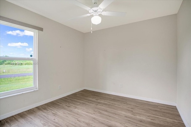 spare room with ceiling fan and light wood-type flooring